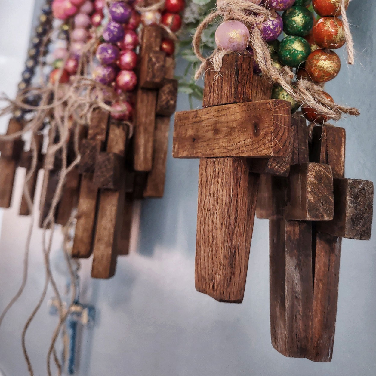 The little crosses are maple or oak, and hang from hand-painted wooden beads, they are a very pretty ornament